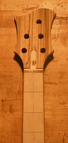 Zebra wood headstock of a five string bass