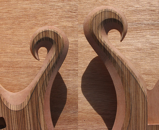 Carved zebrawood scrolls (horns) of a 5 string bass