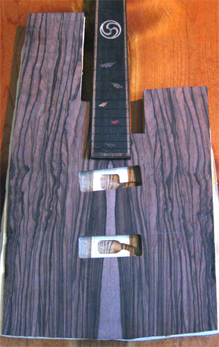 Front of the custom bass guitar with bookmatched macassar ebony top (and centerline) and angled pickup pockets