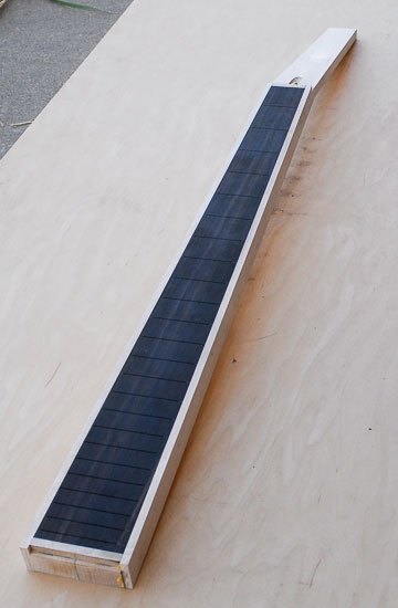 Black bass guitar neck with white stripes down either side