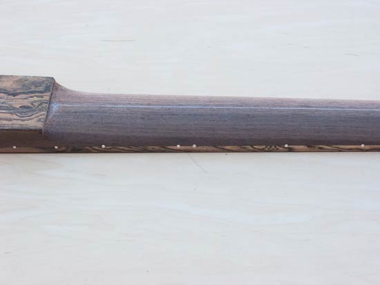 Carved profile of a five string bass neck