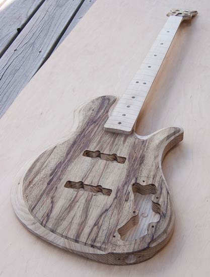 Black limba bass guitar with single-cut shape, maple neck