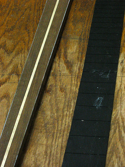 Panga panga neck and ebony fretboard of a custom four string bass, close up