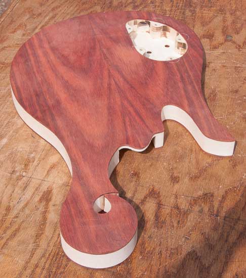 Custom bass guitar with exotic scroll, maple and bloodwood