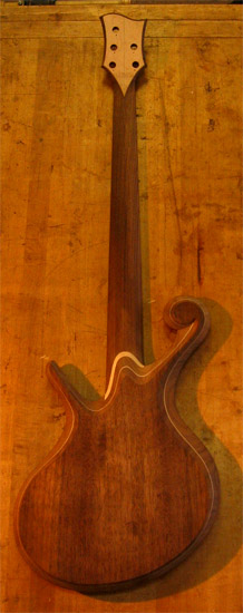 Black walnut back of a fretless custom bass