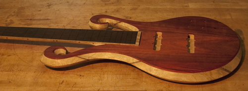 Arm bevel of a six string bloodwood and black limba bass
