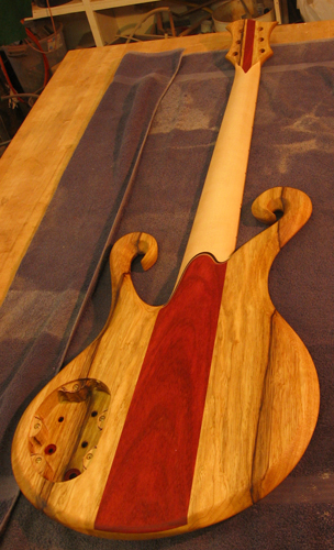 Custom 6 string bass from the back with bloodwood stripe through black limba
