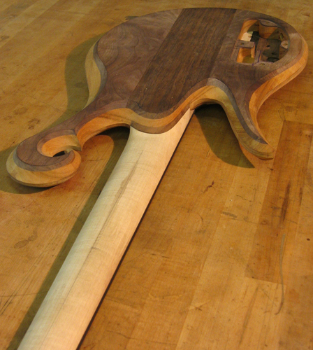 Custom bass guitar's back with maple neck and carved scroll