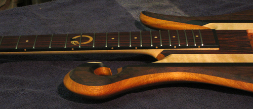 Side of a Xylem custom bass with an Uroboros fretboard inlay
