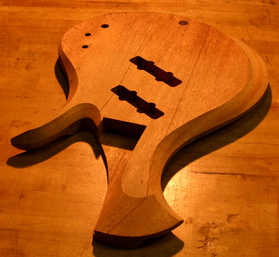 Carved arm bevel and upper horn on a mahogany bass
