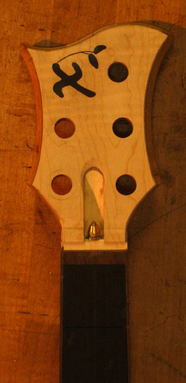 Xylem logo on a curly maple bass headstock