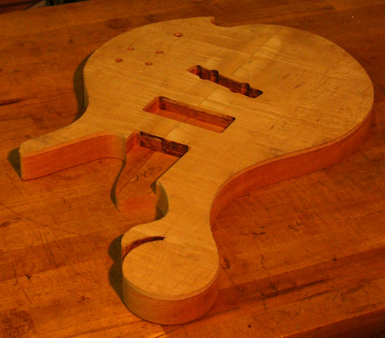 Scroll and neck pocket of a flamed maple bass