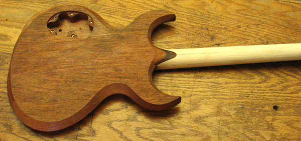 Back of the guitar showing the body, neck, neck shim and the threaded inserts in the control cavity