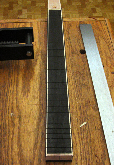 The neck with slotted ebony fretboard, rock maple stripes down the sides and ebony binding