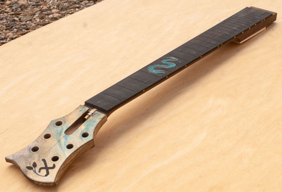 Custom guitar neck with dragon inlay, colored burl headstock cap