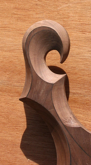 Carved black walnut scroll on a custom guitar